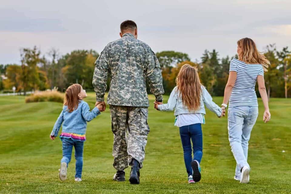 Soldier walking holding hands with his family