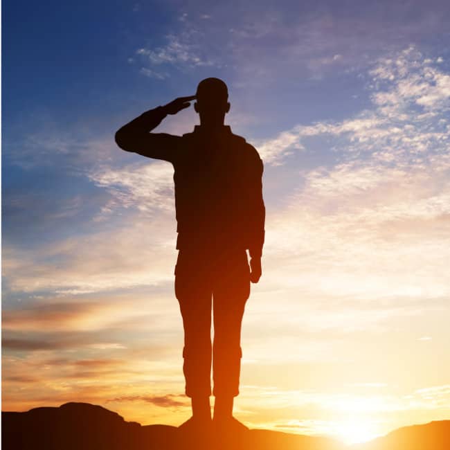 Soldier salutes in sunset